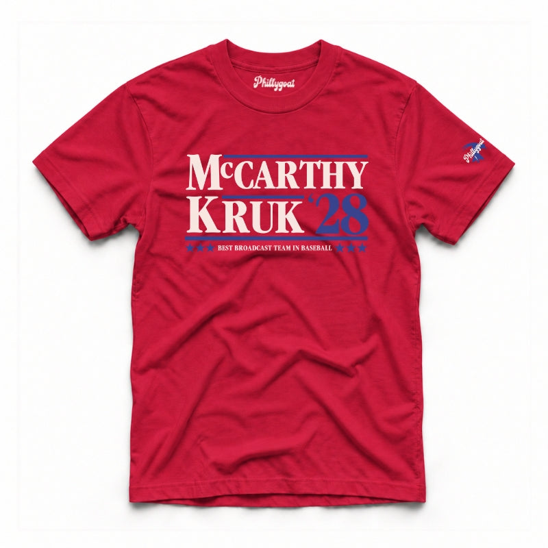 A red short-sleeve t-shirt with a political graphic reading 'McCarthy Kruk 28' in white and red, with 'PHILIGOAT' printed inside the collar, shown flat on a white background.