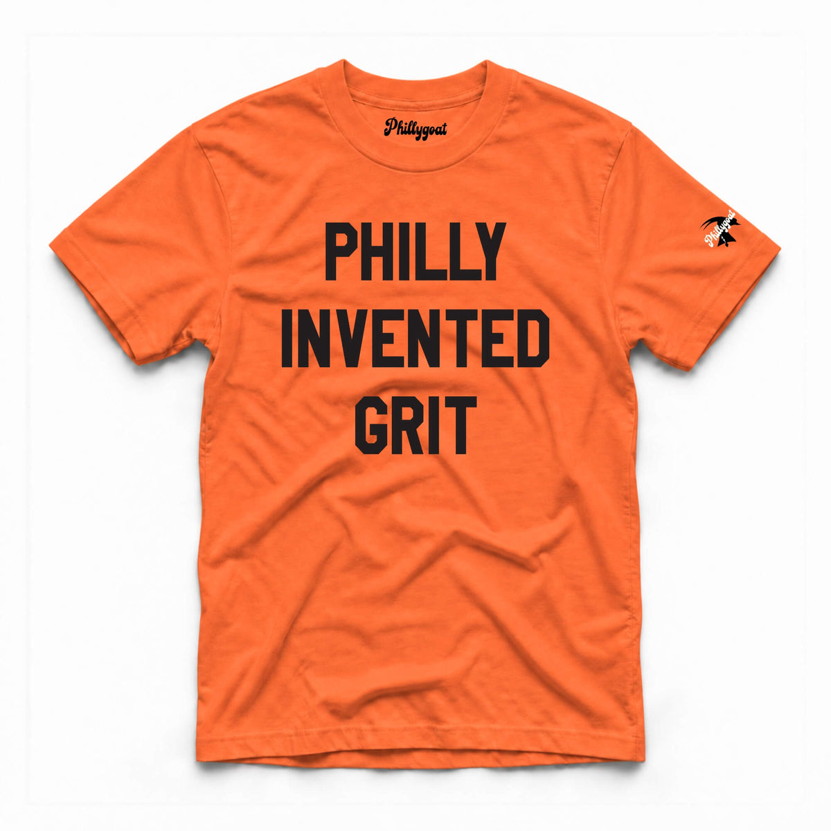 An orange short-sleeve t-shirt with the words 'PHILLY INVENTED GRIT' printed in bold black capital letters across the chest. The brand name 'Phillygoat' is visible on the inner neck label and as a small graphic on the left sleeve.