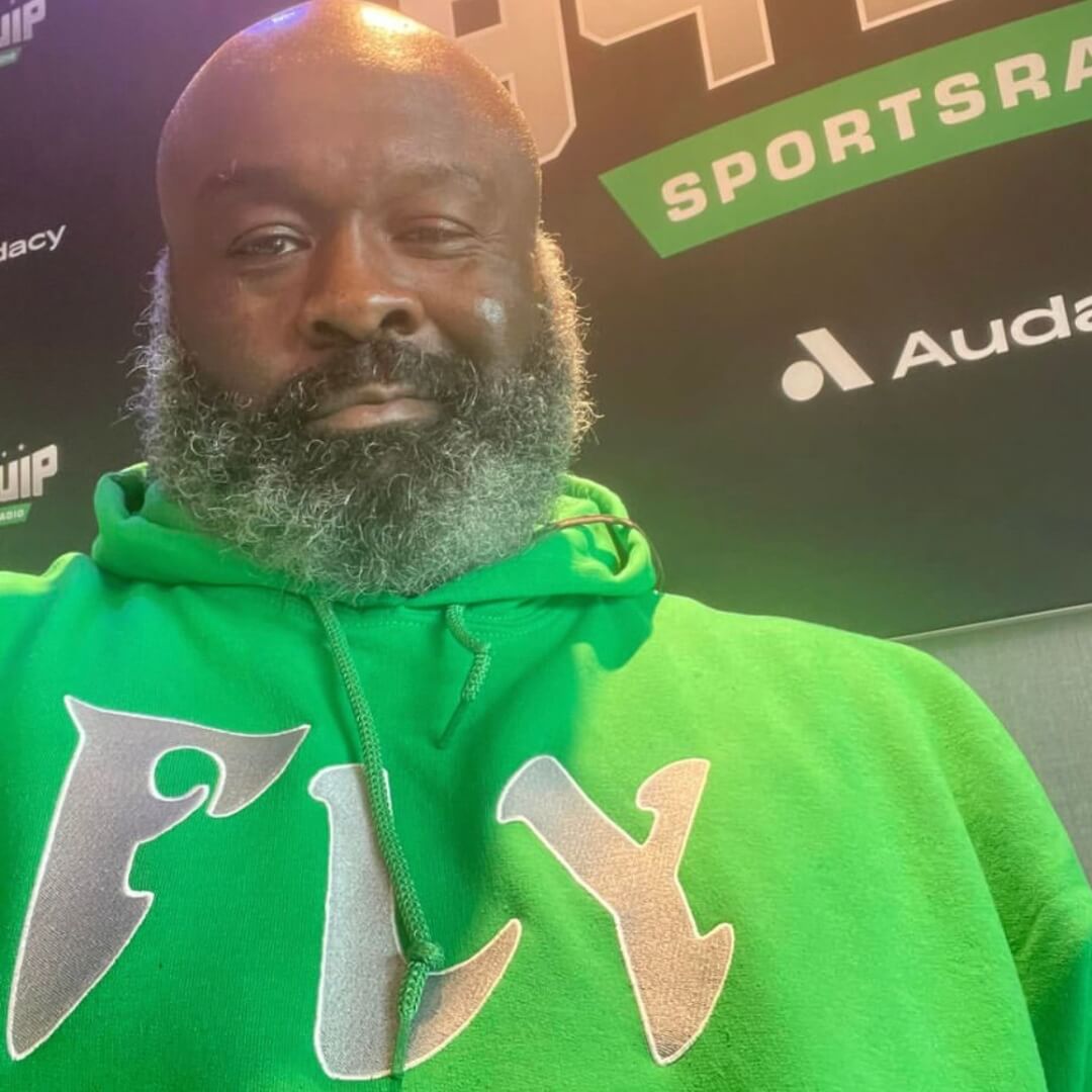 Hugh Douglas wearing a kelly green Philadelphia Eagles FLY hoodie from Phillygoat