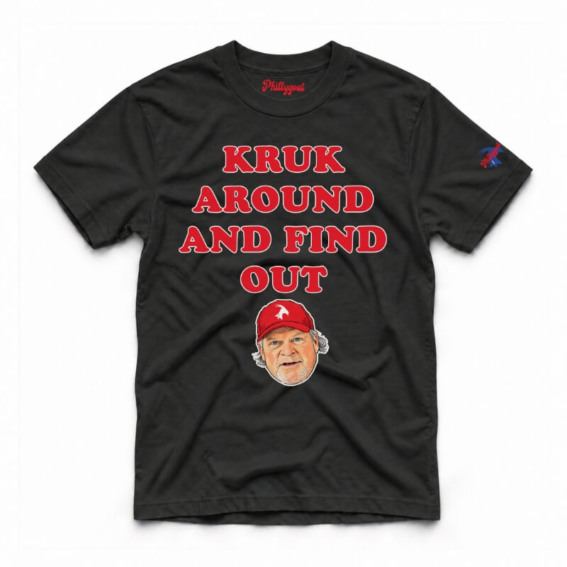 A black short-sleeve graphic t-shirt featuring the text 'KRUK AROUND AND FIND OUT' in cream block letters, a cartoon caricature of John Kruk wearing a blue cap, and a small blue logo on the right sleeve, displayed flat against a white background.