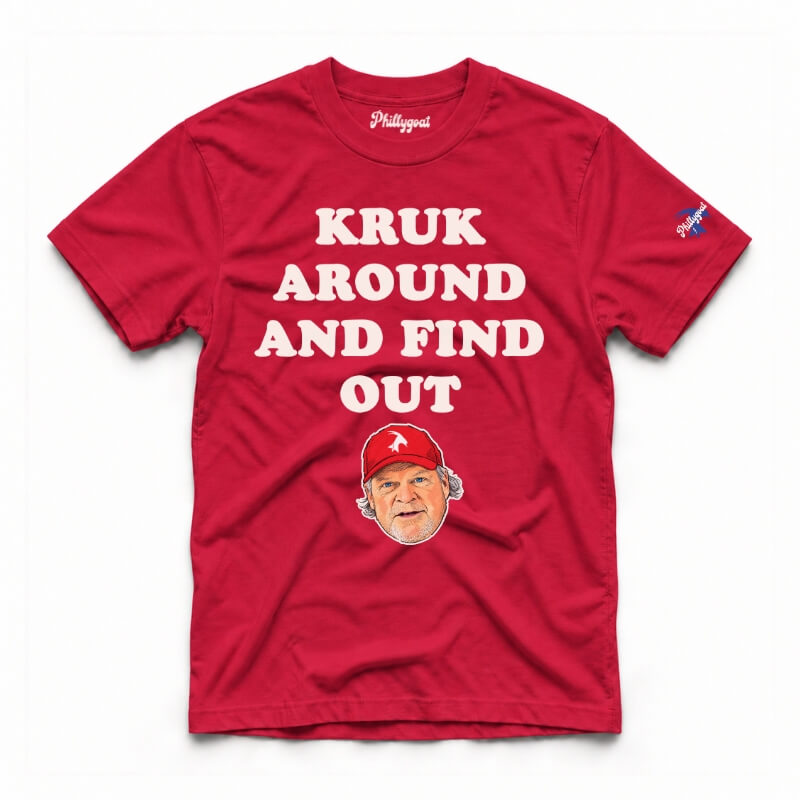 A red short-sleeve graphic t-shirt featuring the text 'KRUK AROUND AND FIND OUT' in cream block letters, a cartoon caricature of John Kruk wearing a blue cap, and a small blue logo on the right sleeve, displayed flat against a white background.