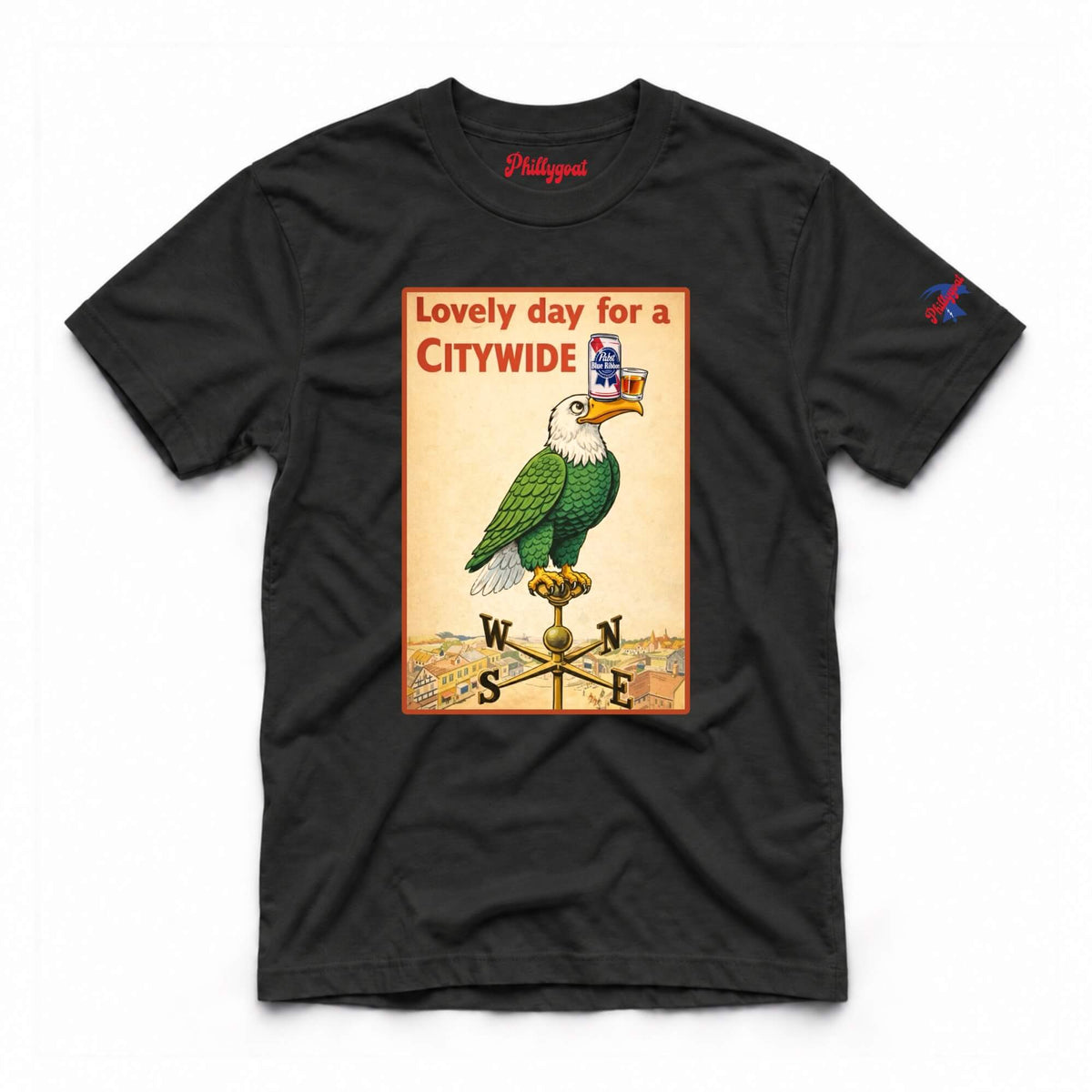 A black short-sleeve graphic t-shirt featuring a vintage-style city poster print of a green bird perched on a weather vane with the text 'Lovely day for a CITYWIDE'. The shirt is displayed flat against a clean white background.